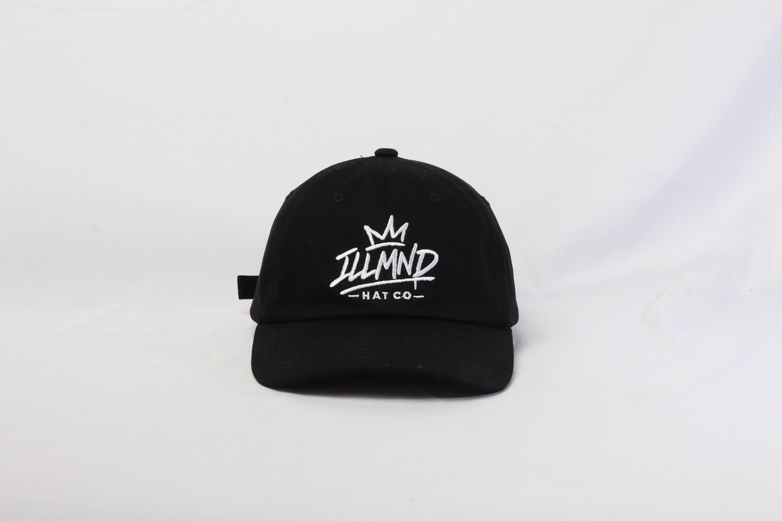 Genesis Cap in black, front view with white ILLMND crown embroidery