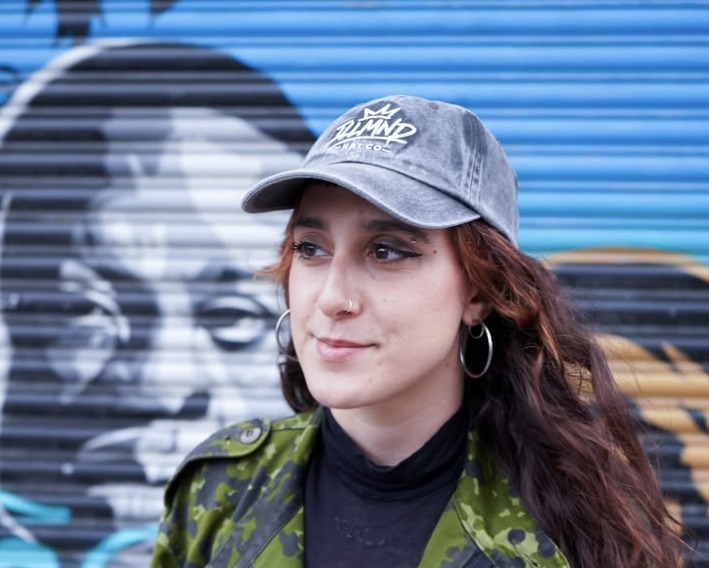 Washed Black Genesis cap worn in front of a painted shutter