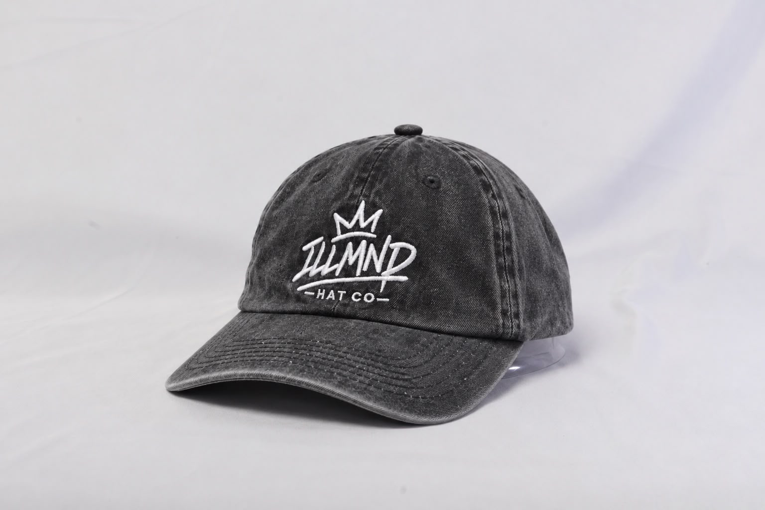 Genesis Cap in washed black, front view with white ILLMND crown embroidery